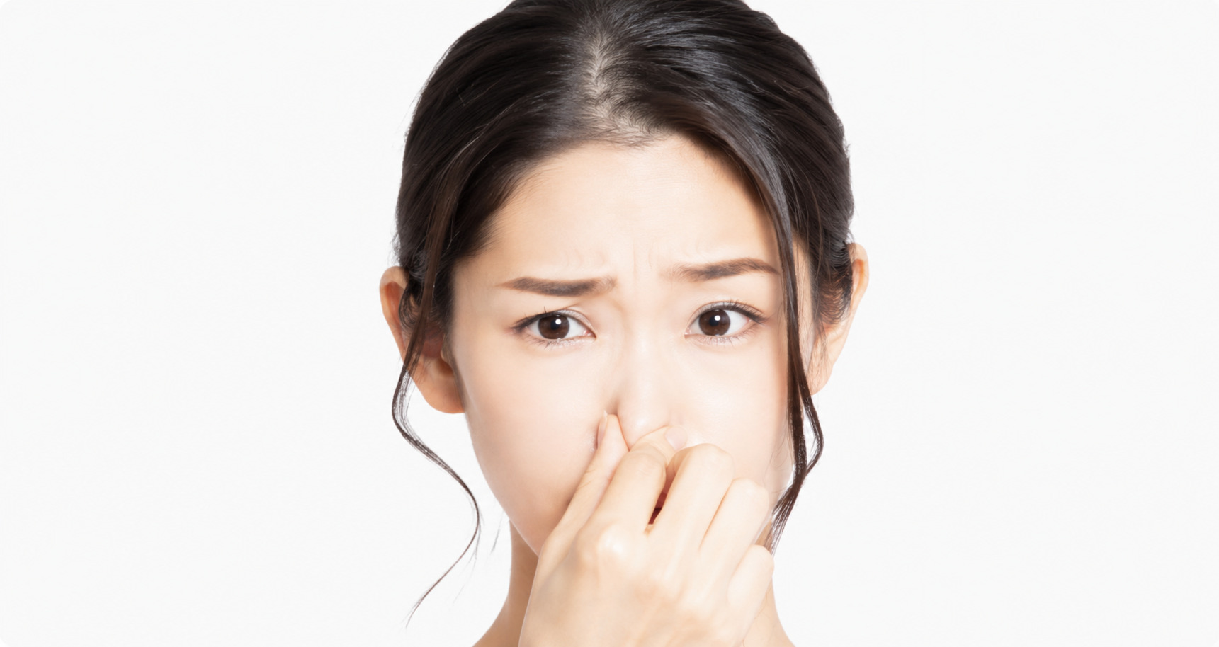 口臭が気になり鼻を押さえる女性